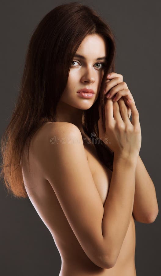 Ritratto di una giovane donna nuda che sta con le mani che la coprono