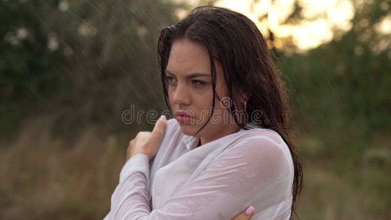 Ritratto di una giovane donna vestita sotto la pioggia fredda, tutto in silenzio. c'è un'emozione di delusione e rabbia