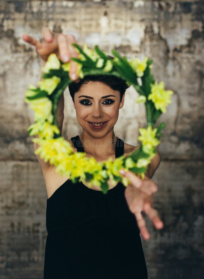 Ritratto di una giovane signora affascinante con una corona del fiore, in una retro blusa La ragazza che esamina pensively la mac immagine stock Ritratto di una giovane signora affascinante con una corona del fiore, in una retro blusa La ragazza che esamina pensively la mac immagine stock