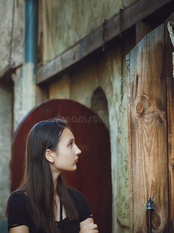 Ritratto di una ragazza abbastanza mora sui precedenti di vecchia costruzione fotografia stock Ritratto di una ragazza abbastanza mora sui precedenti di vecchia costruzione fotografia stock