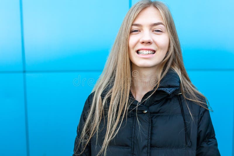 Ritratto di una ragazza allegra e sorridente su fondo blu, con il posto isolato per testo fotografia stock Ritratto di una ragazza allegra e sorridente su fondo blu, con il posto isolato per testo fotografia stock