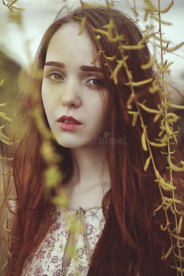 Ritratto di una ragazza romantica con capelli rossi nel vento sotto un albero di salice immagini stock Ritratto di una ragazza romantica con capelli rossi nel vento sotto un albero di salice immagini stock
