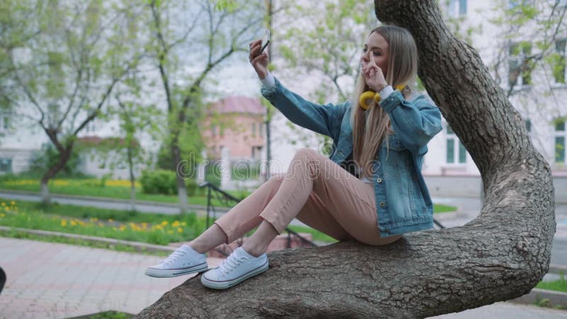 Ritratto di una ragazza sorridente che fa la foto del selfie in parco