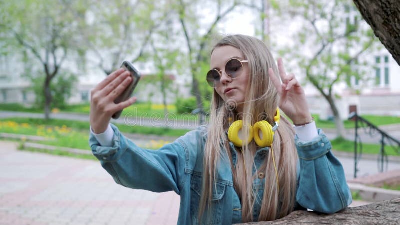 Ritratto di una ragazza sorridente che fa la foto del selfie in parco