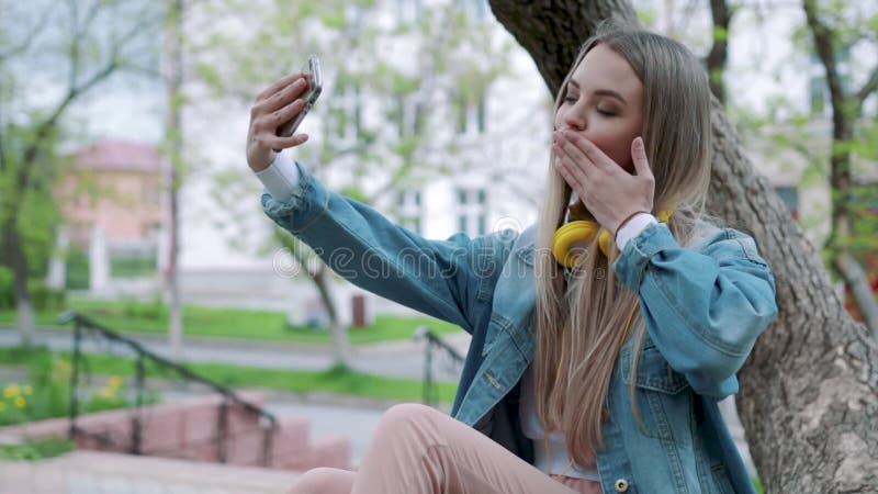 Ritratto di una ragazza sorridente che fa la foto del selfie in parco