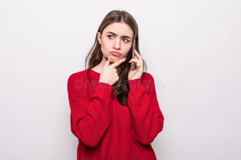 Portrait of thoughtful doubtful woman talking on mobile phone and looking up  over white background. Portrait of thoughtful doubtful woman talking on mobile phone and looking up  over white background