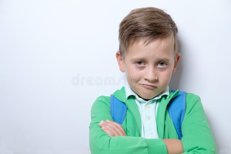 Ritratto di uno scolaro sveglio con lo zaino blu su un backg bianco immagine stock libera da diritti Ritratto di uno scolaro sveglio con lo zaino blu su un backg bianco immagine stock libera da diritti