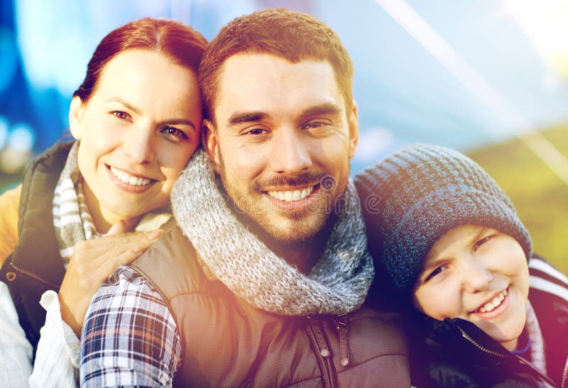 Tourism, hike and travel concept - happy family portrait over tent at camp site. Tourism, hike and travel concept - happy family portrait over tent at camp site