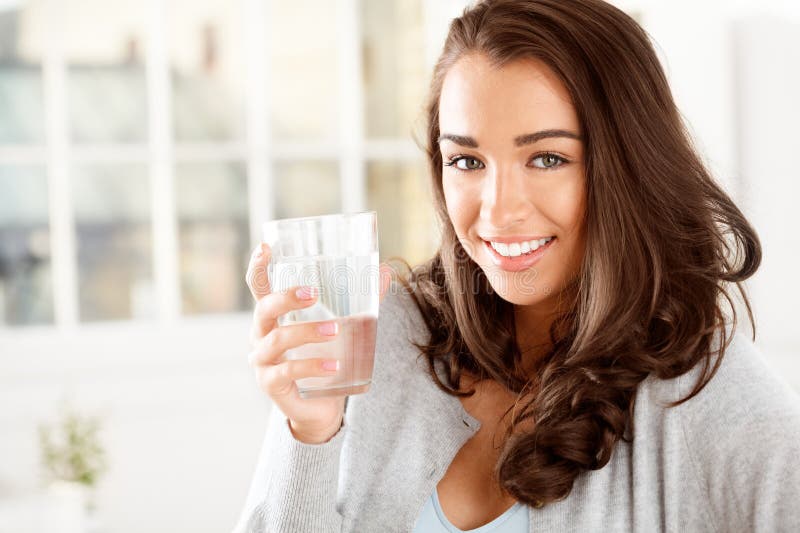 Ritratto femminile e acqua in vetro per idratazione sanitaria per sete e nutrizione con bevande a casa. elettroliti fotografia stock