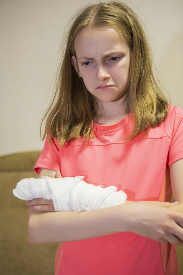 Ritratto giù della ragazza caucasica con la mano danneggiata in gesso fotografia stock libera da diritti Ritratto giù della ragazza caucasica con la mano danneggiata in gesso fotografia stock libera da diritti