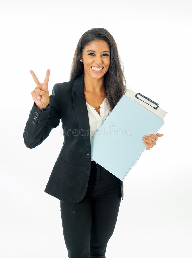 Ritratto integrale della donna latina corporativa latina attraente che sembra eccitata e che tiene cartella e lavoro di ufficio i immagine stock libera da diritti Ritratto integrale della donna latina corporativa latina attraente che sembra eccitata e che tiene cartella e lavoro di ufficio i immagine stock libera da diritti