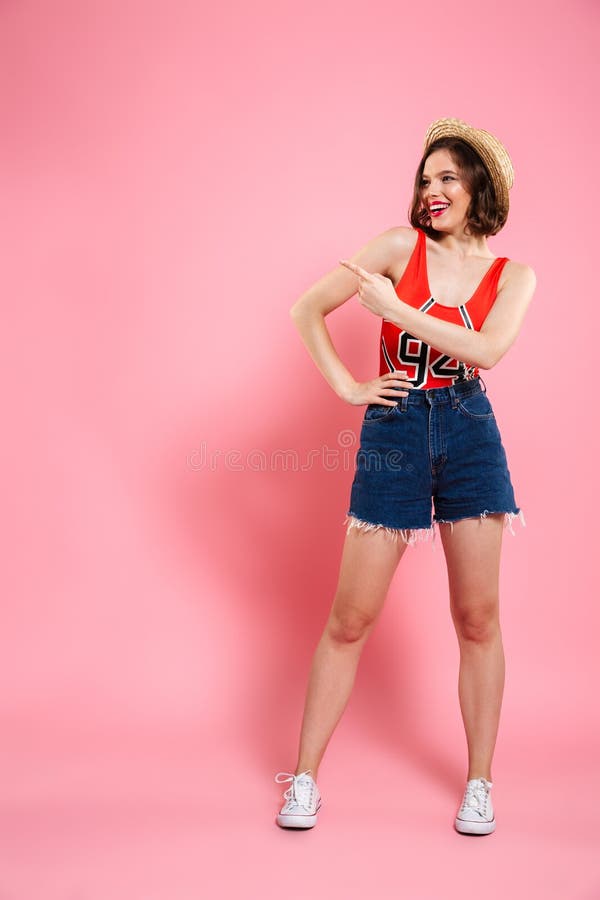 Ritratto integrale della ragazza teenager sorridente in tuta e nel je rossi immagini stock Ritratto integrale della ragazza teenager sorridente in tuta e nel je rossi immagini stock