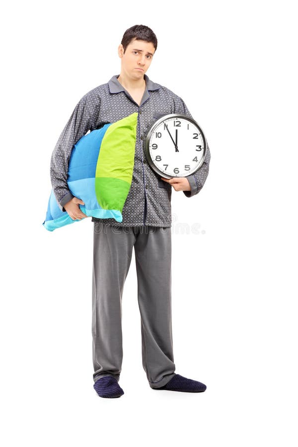 Ritratto integrale di giovane tipo sonnolento che giudica un orologio di parete fotografia stock Ritratto integrale di giovane tipo sonnolento che giudica un orologio di parete fotografia stock