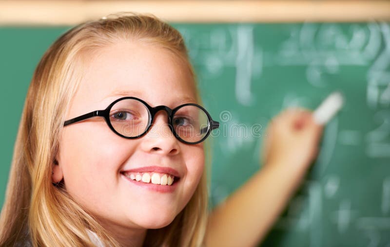 Ritratto nerd e ragazzo felice che scrive sulla lavagna in classe per imparare educazione e studiare matematica. occhiali e immagini stock