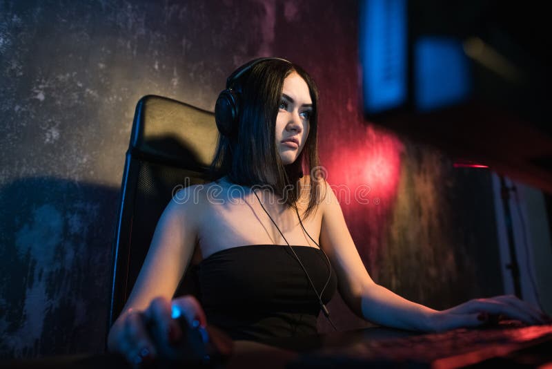 Ritratto sparato di bella ragazza professionale sorridente del Gamer che gioca in video gioco online dello sparatutto in prima pe fotografia stock libera da diritti Ritratto sparato di bella ragazza professionale sorridente del Gamer che gioca in video gioco online dello sparatutto in prima pe fotografia stock libera da diritti