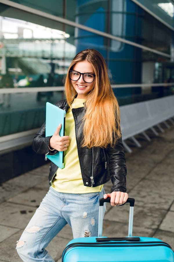 Ritratto verticale della ragazza graziosa con capelli lunghi che stanno fuori nell'aeroporto Porta il rivestimento nero con i jea fotografia stock Ritratto verticale della ragazza graziosa con capelli lunghi che stanno fuori nell'aeroporto Porta il rivestimento nero con i jea fotografia stock