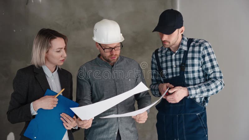 Riunione nel cantiere. un ingegnere un costruttore e una donna architetta stanno discutendo la progettazione di una nuova casa stock footage