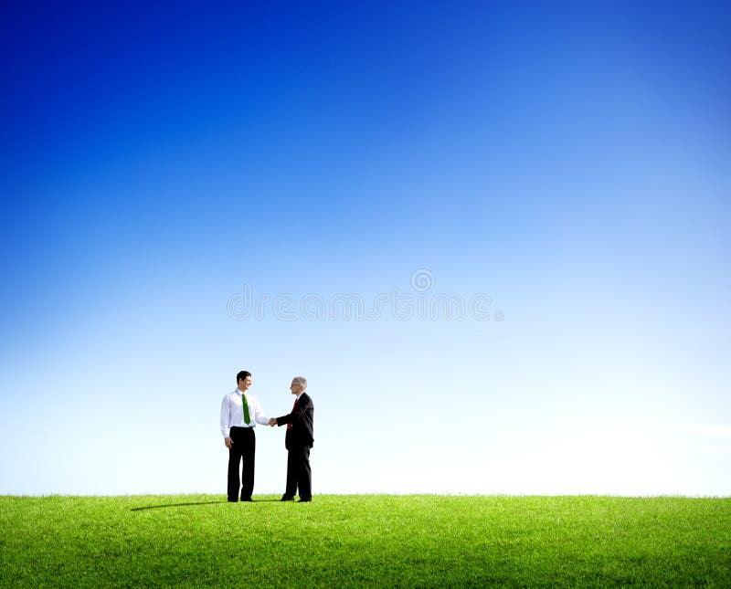 Riuscito accordo all'aperto di affari in un campo fotografie stock Riuscito accordo all'aperto di affari in un campo fotografie stock