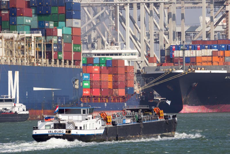 ROTTERDAM, NETHERLANDS - MAR 16, 2016: River barge passing ocean container ships in the Port of Rotterdam. Barges rotterdam stock images, royalty-free photos and pictures