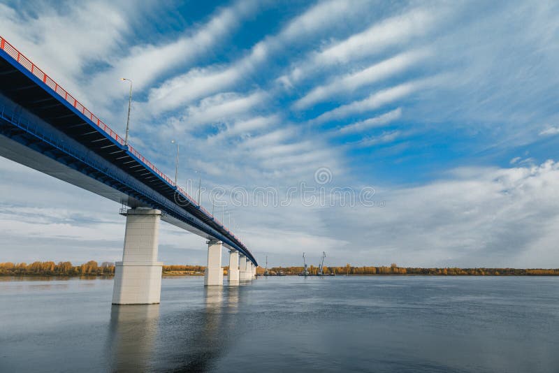 River gateway bridge blue sky and clouds. Autumn River bridge view. Cargo ships loading in cargo terminal on background
