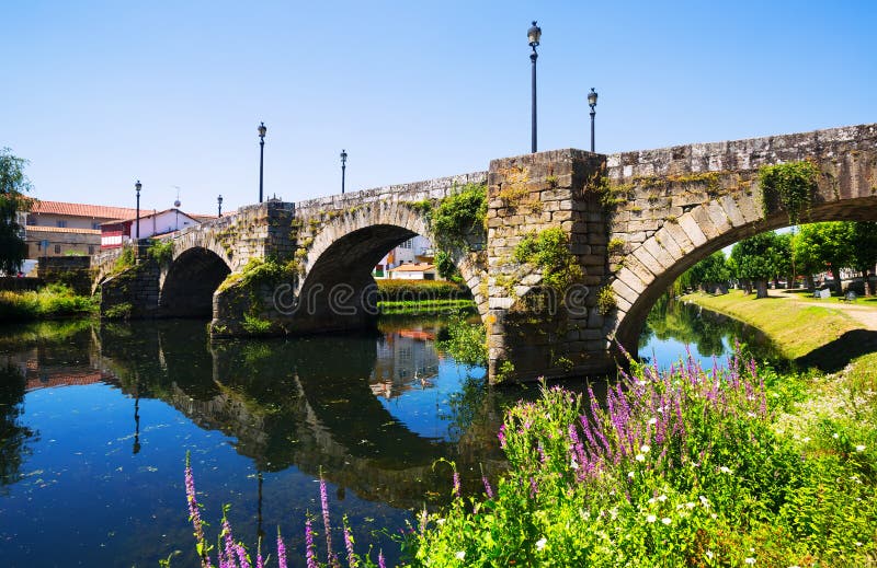 Cabe river and old stone bridge at Monforte de Lemos in summer. Galicia, Spain