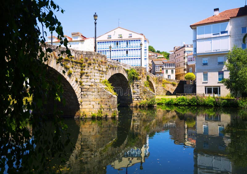 River and old stone bridge at Monforte de Lemos in sunny summer day. Galicia, Spain