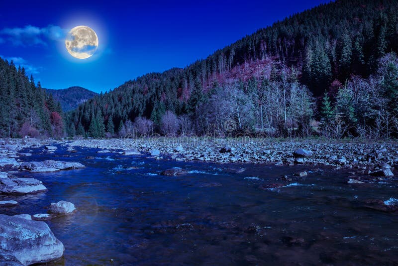 River rocky shore near the autumn mountain forest