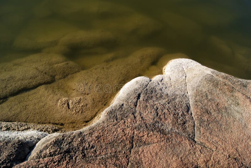 River with a Rocky Shore. Texture with Water and Granite Stock Image