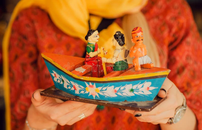 Riverboat with indian family in forms of colorful wooden toy in traditional style of India, in hands of woman in sari. Dress stock images Riverboat with indian family in forms of colorful wooden toy in traditional style of India, in hands of woman in sari. Dress stock images