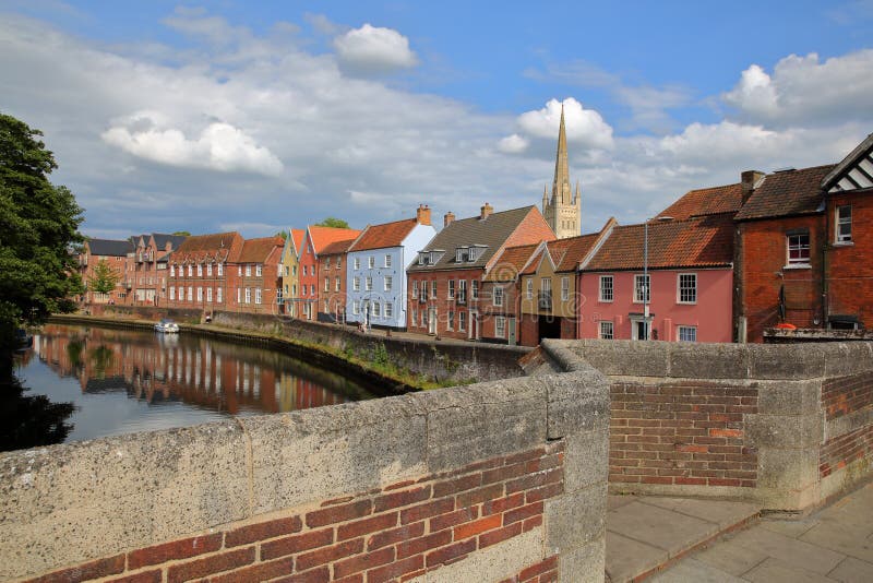 The riverside river Wensum in Norwich Norfolk, UK with colorful houses and the tower and spire of the Cathedral in the backgro