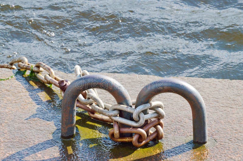 Rivesta di ferro la catena sul pilastro del fiume fotografia stock libera da diritti Rivesta di ferro la catena sul pilastro del fiume fotografia stock libera da diritti