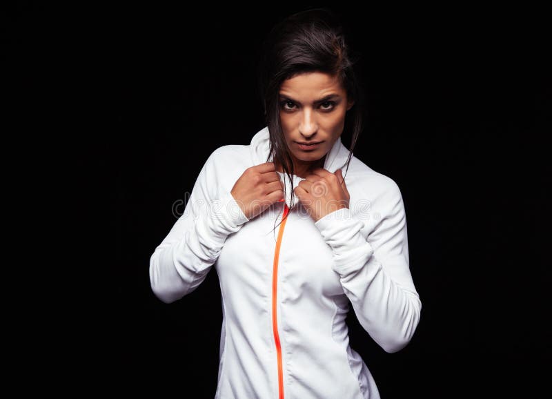 Rivestimento di sport d'uso della giovane donna sicura fotografie stock Rivestimento di sport d'uso della giovane donna sicura fotografie stock