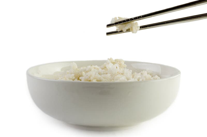 A bowl of cooked brown rice, in an Asian style bowl, with chopsticks isolated on white. A bowl of cooked brown rice, in an Asian style bowl, with chopsticks isolated on white