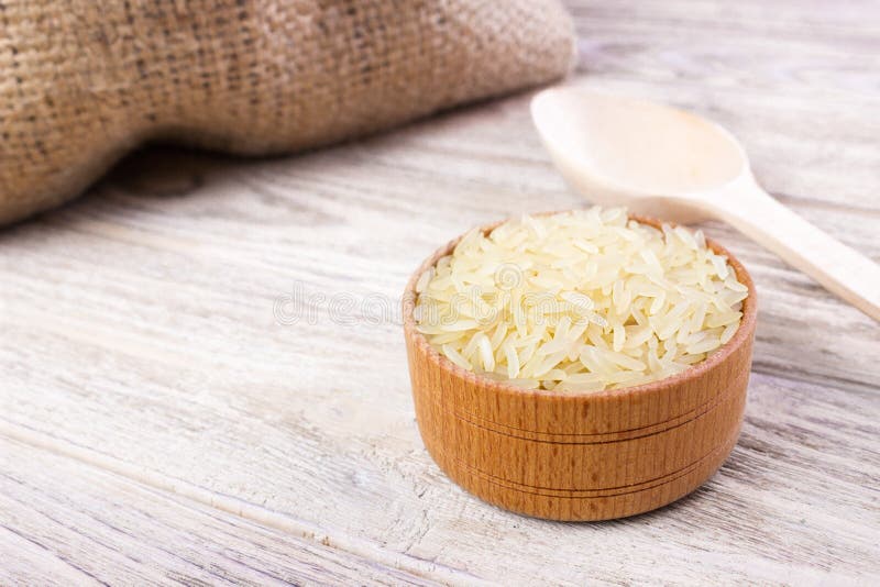Riz de jasmin dans une cuvette en bois sur le fond en bois photos stock Riz de jasmin dans une cuvette en bois sur le fond en bois photos stock