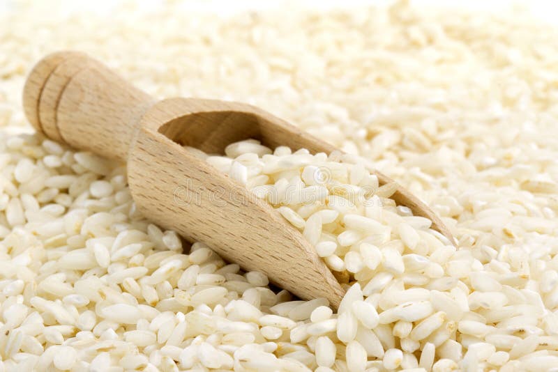 Backdrop of risotto rice with wooden scoop. Backdrop of risotto rice with wooden scoop