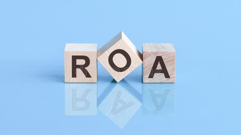 ROA is an abbreviation of the Return On Assets - the text is written on wooden cubes, one of the cubes stands on an edge, blue background, reflection. Letters roa stock images, royalty-free photos and pictures