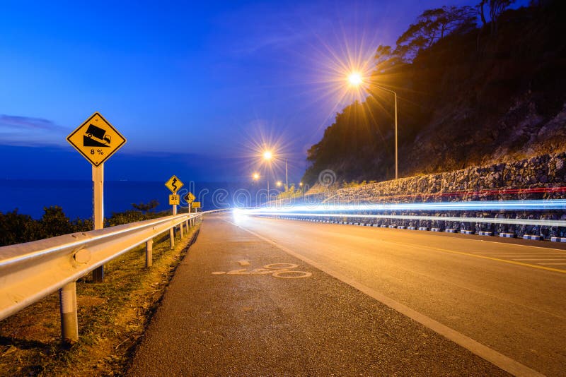 The Road with Car Lights on the Hill Near the Coast at Night Stock