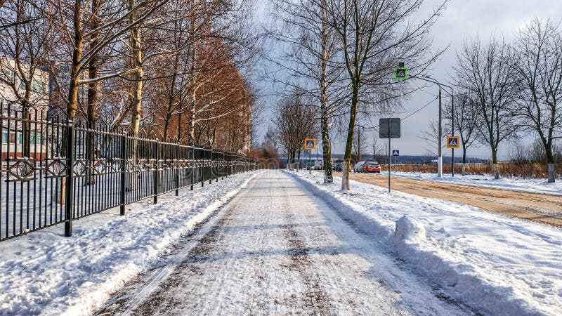 Road in the city in winter, cleaned snow cleaned the street from the snow in the park.