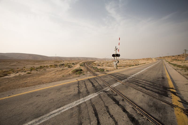 Road crossing rail in desert