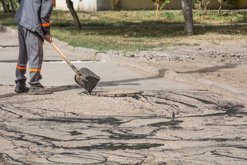Road Repair Workers Pour Resin Road Surface To Cover The Asphalt Stock road-repair-workers-pour-resin-road-surface-to-cover-the-asphalt-stock