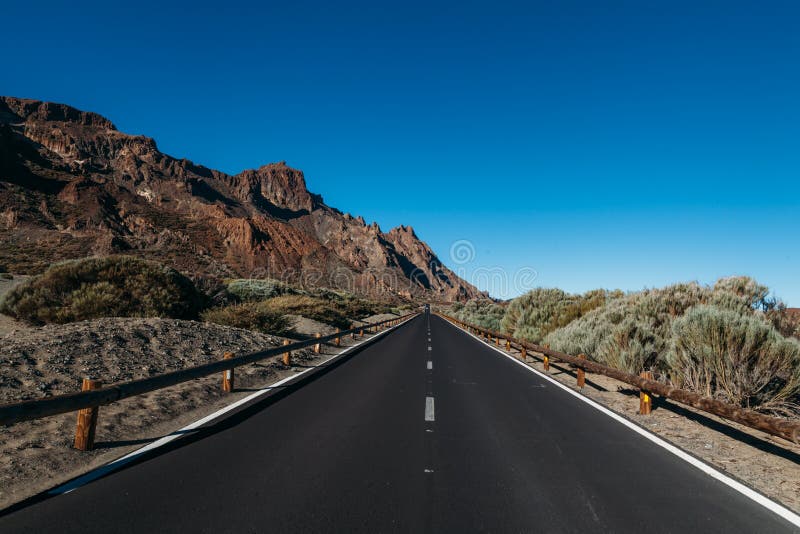 Road among the rocks in the desert to the volcano Teide stock image Road among the rocks in the desert to the volcano Teide stock image