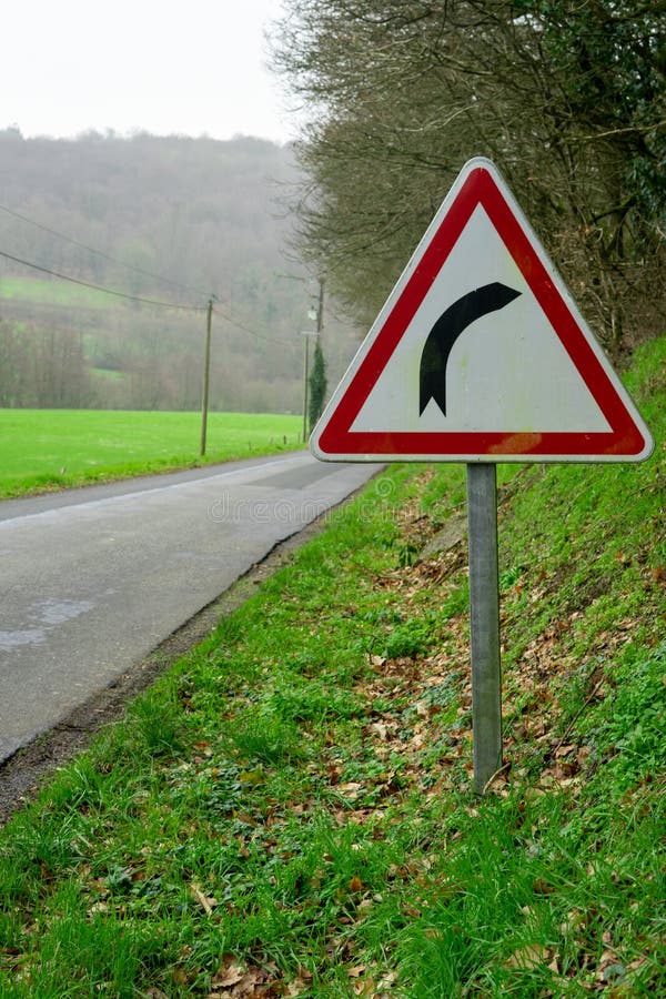 Dangerous turns, triangle warning traffic sign near rural road Stock Photo  - Alamy