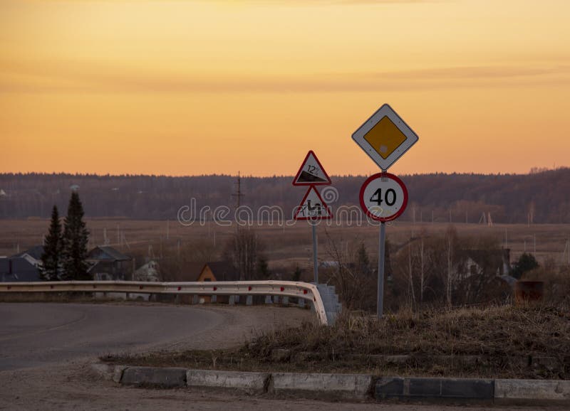 Road Signs Against the Background of Orange Sunset Sky. Stock Image