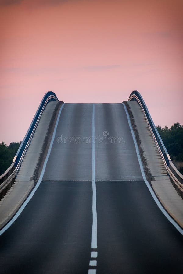 Road at sunset through the bridge to the island of Vir.