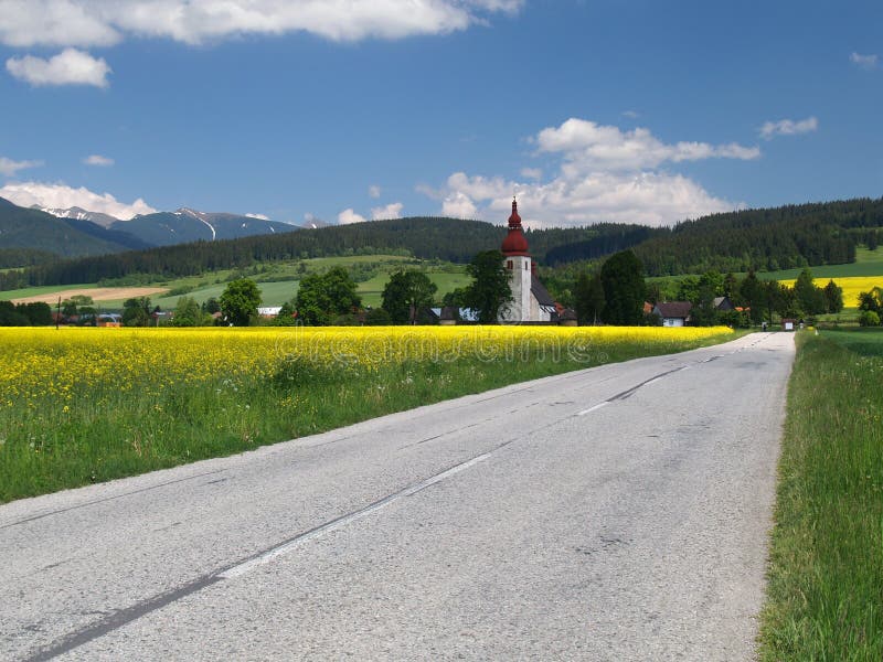 Road to church of Saint Ladislav. Summer view yellow and green meadow with road to historical Roman-Catholic church of Saint Ladislav (kostol svätého stock image Road to church of Saint Ladislav. Summer view yellow and green meadow with road to historical Roman-Catholic church of Saint Ladislav (kostol svätého stock image