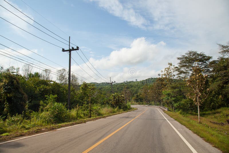 Road trip to the mountains. There are trees and mountains on both sides of the road along the way.