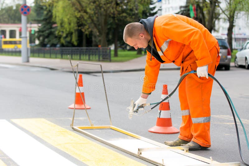 Road worker marking pedestrian crossing line