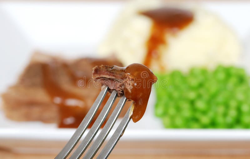 Roast beef and gravy on a fork stock image