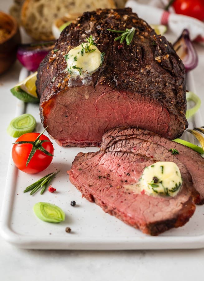 Roast Beef with Sauce and Meat Fork on White Background. Copy Space