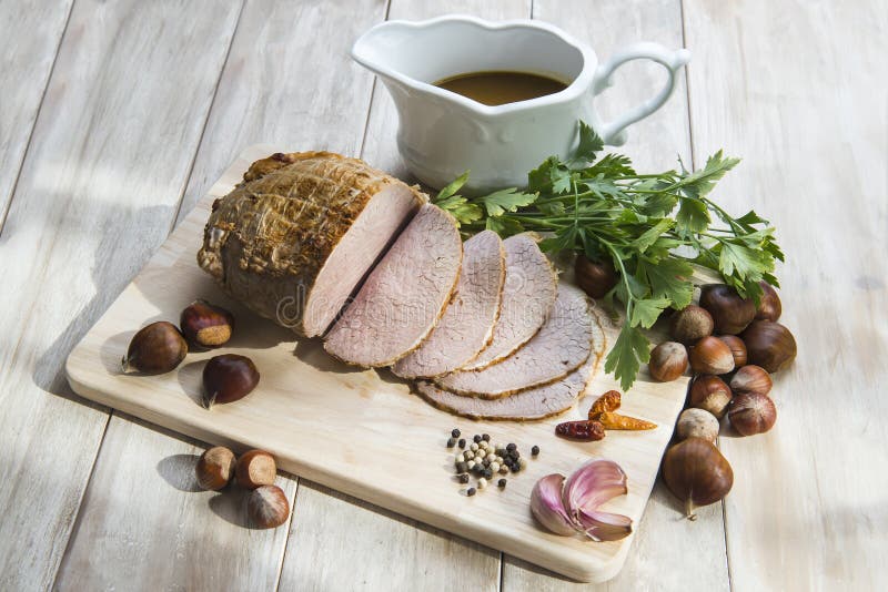 Sliced roast beef with some ingredients on the table of the kitchen